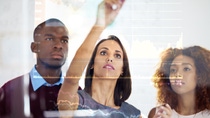 Shot of a group of business colleagues using a digital interface while standing in a modern office Shot of a group of business colleagues using a digital interface while standing in a modern office